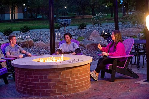 student sitting around fire pit