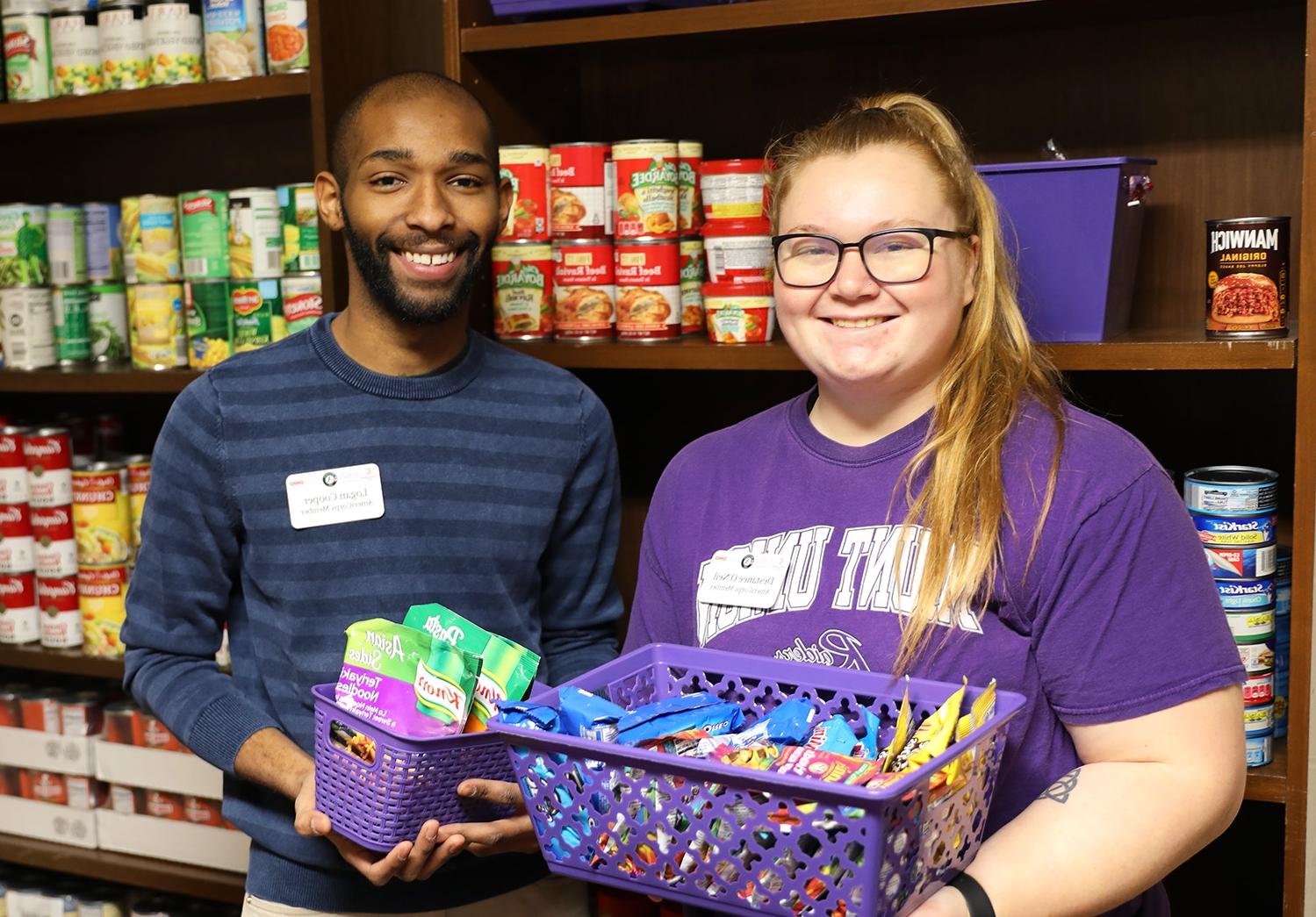 Students holding canned goods in Raiders Cove